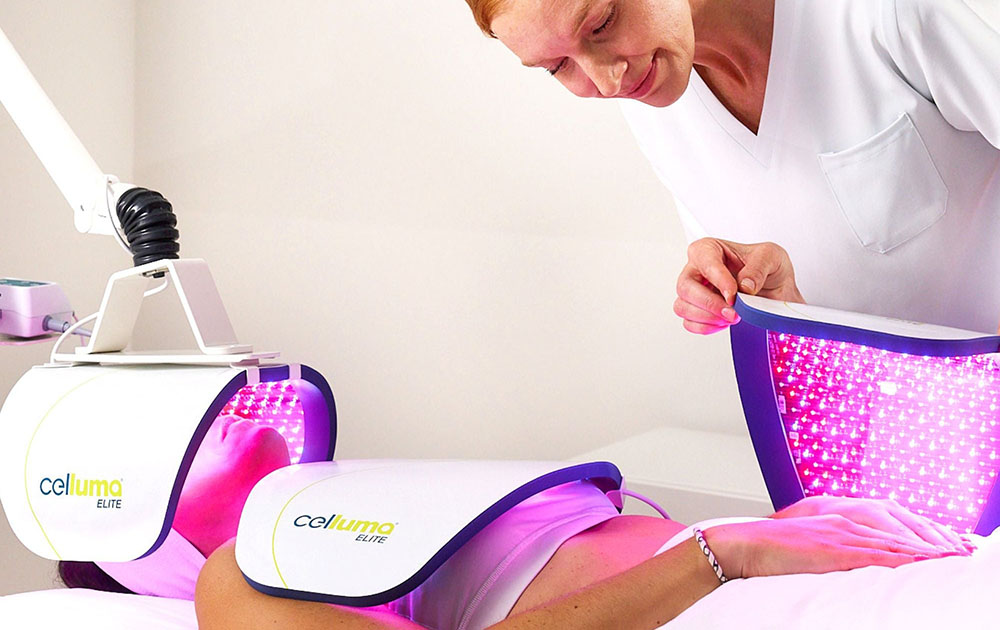 Practitioner preparing female patient for led light therapy.
