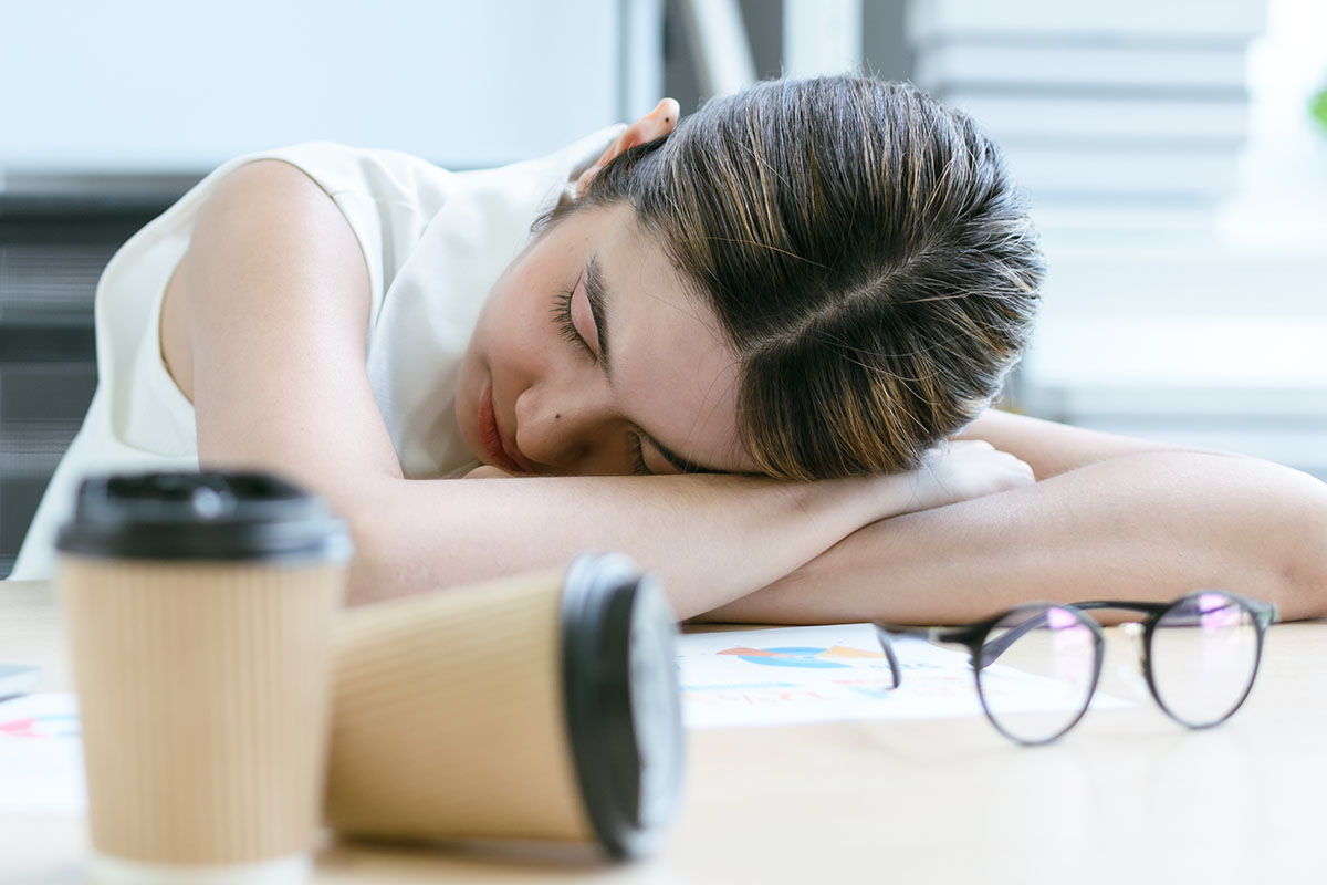 Woman experiencing an afternoon energy crash while working at her desk