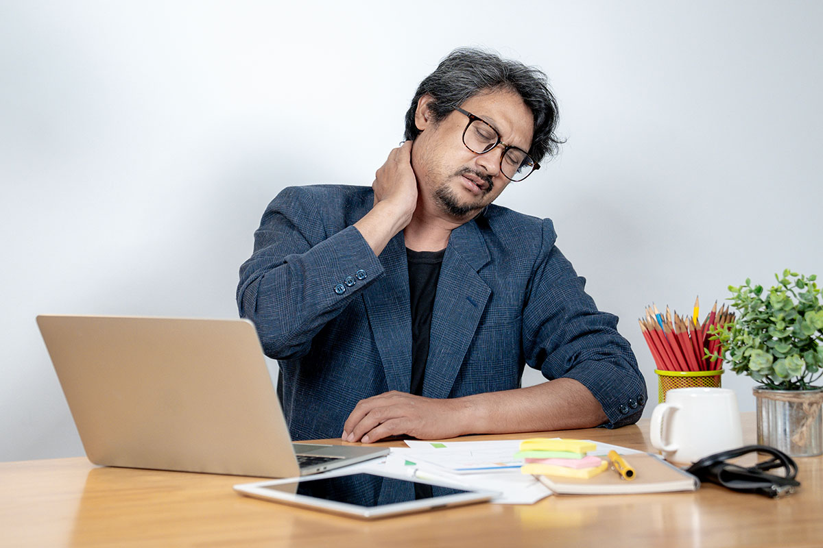 Office worker experiencing neck and shoulder tension after prolonged computer work